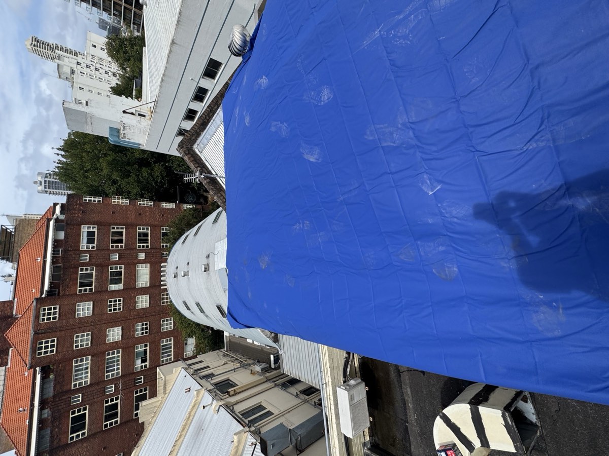 Blue tarp over a roof after an emergency repair